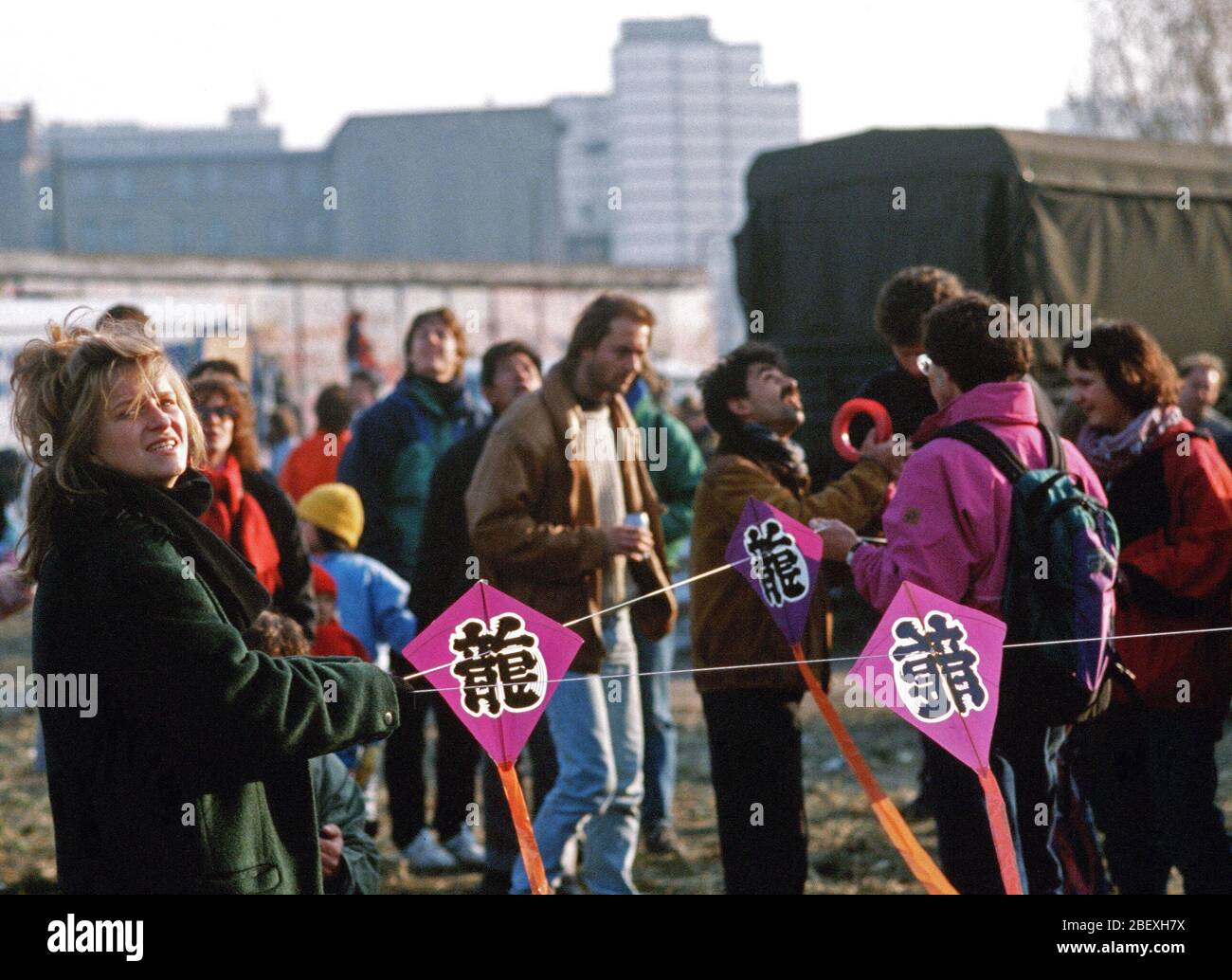 An East German woman holds onto a kite string as she celebrates the demolition of a section of the Berlin Wall at Potsdamer Platz. Stock Photo