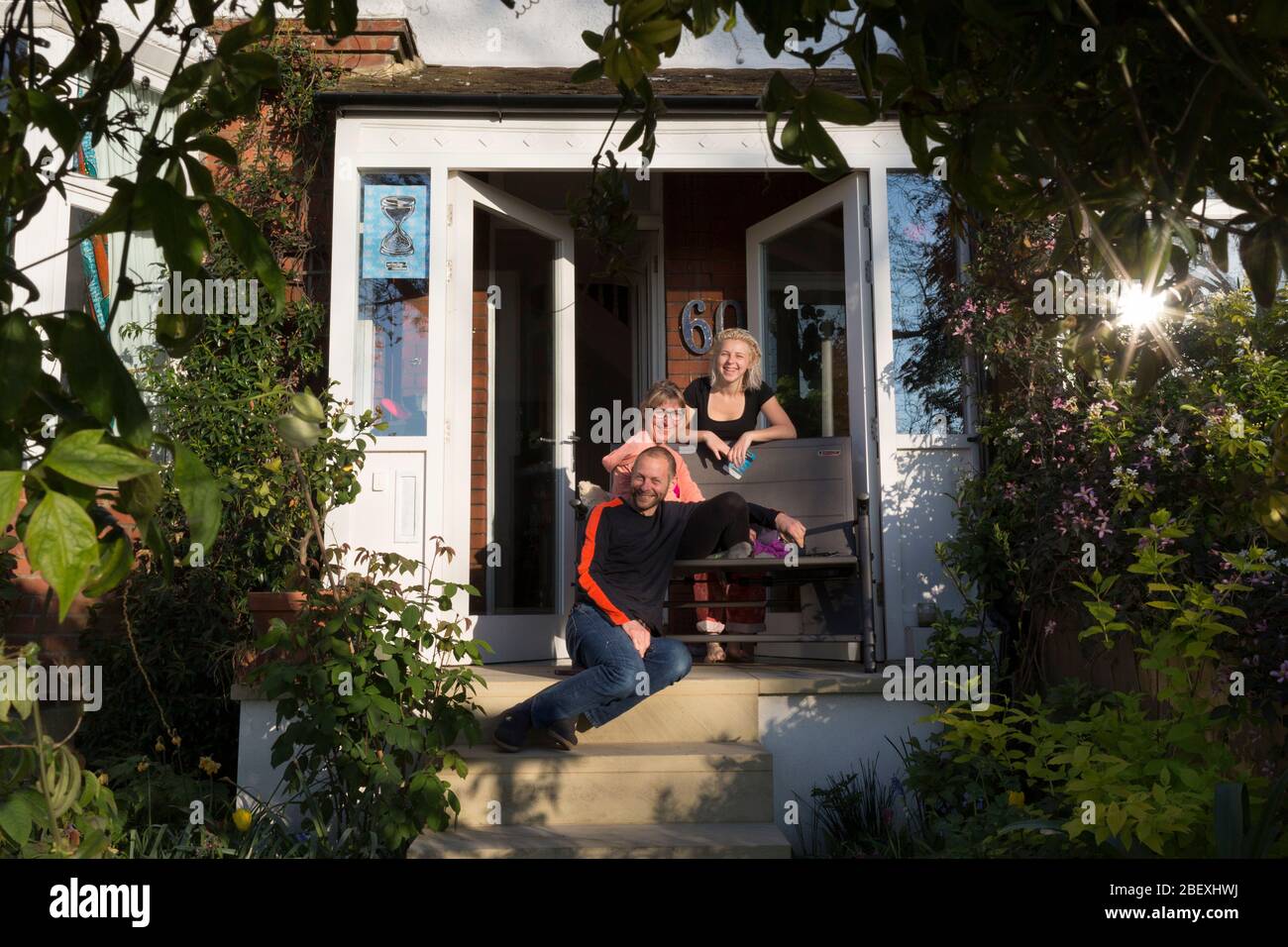 In the third week of the UK government's lockdown during the Coronavirus pandemic, when the daily UK death rate rose by another 761 to 12,868 and with nearly 100,000 reported cases. a south London family stay at home on the porch of their south London home, on 15th April 2020, in London, England. Stock Photo