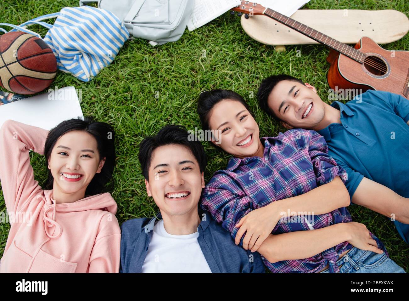 Happy students lay on the grass Stock Photo