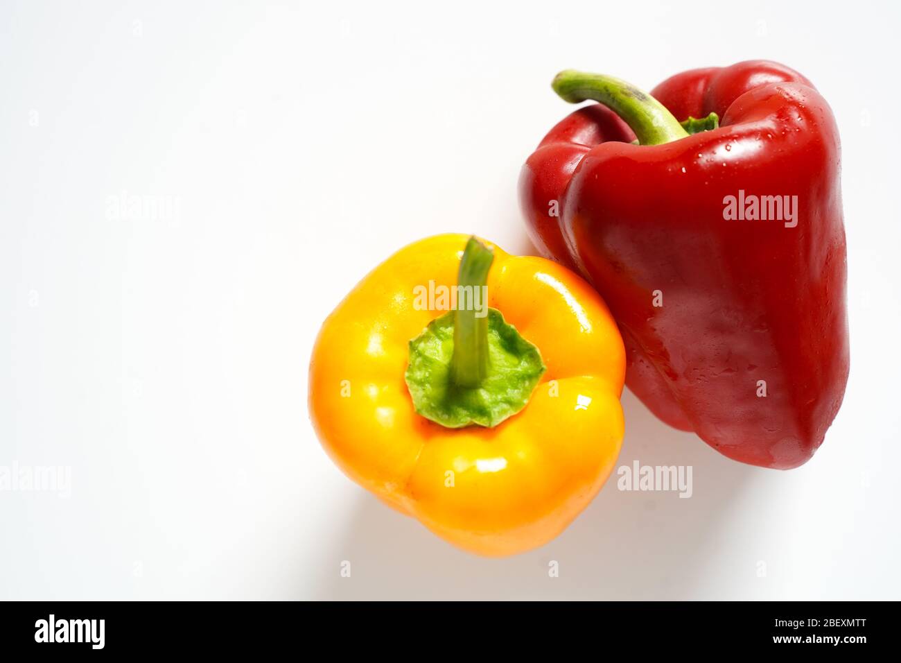 A whole red and yellow pepper on a plain white background Stock Photo ...