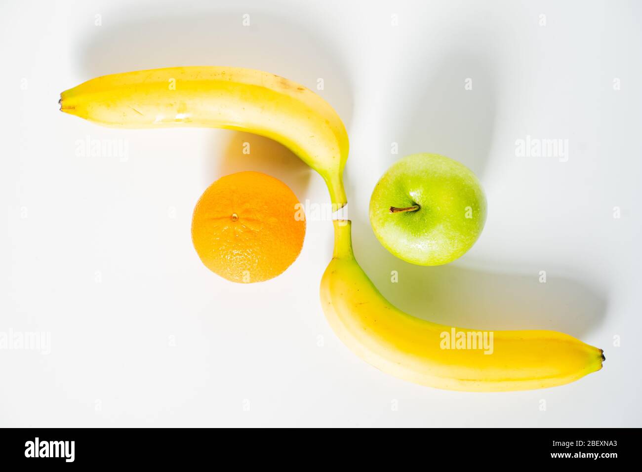 Two whole bananas laid at opposite ends with an apple and orange to