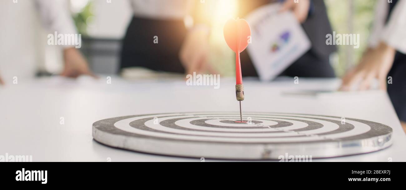 target and goal concept, dart on board with business people group