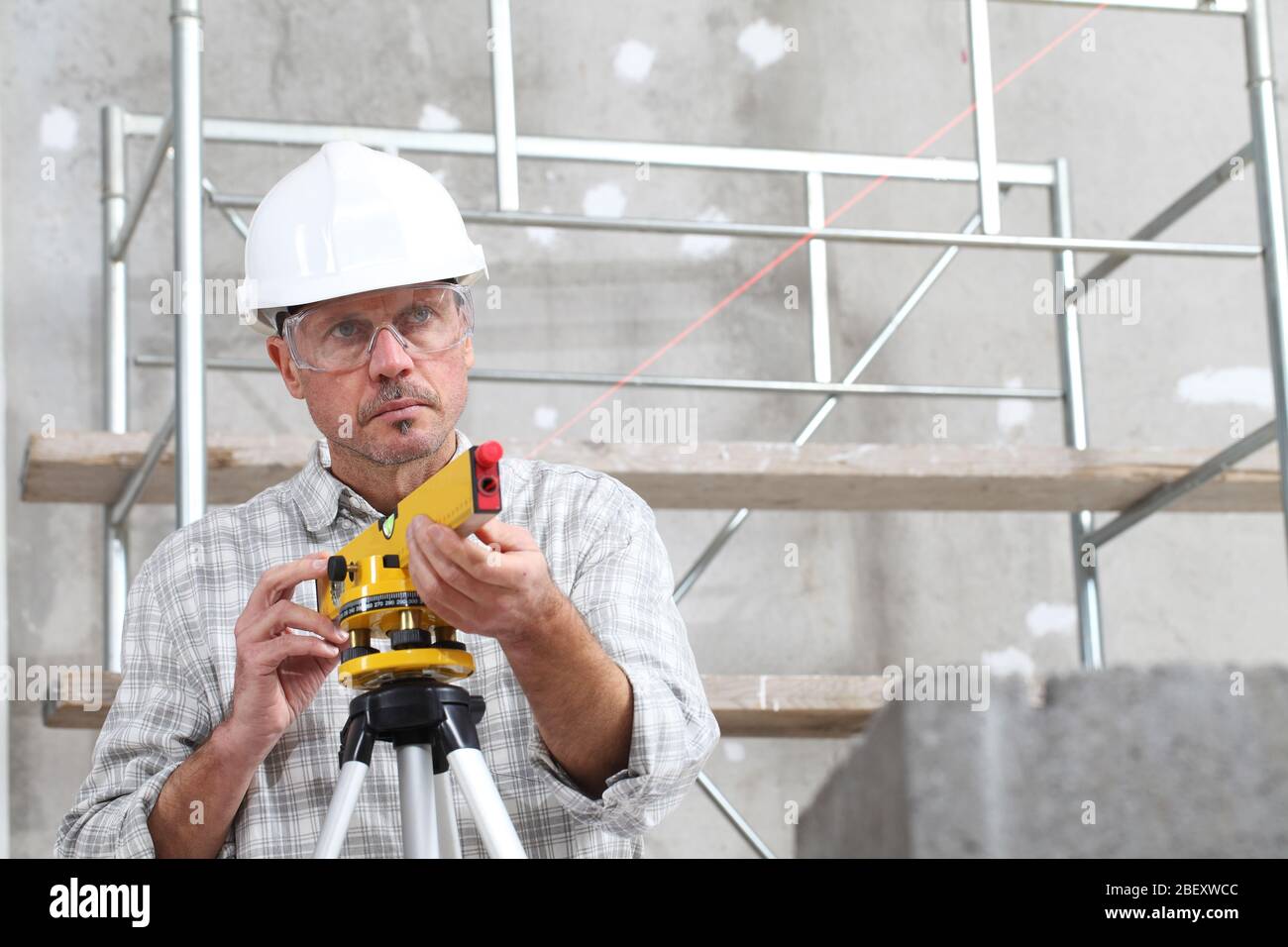 Construction worker using laser measuring tool Stock Photo - Alamy