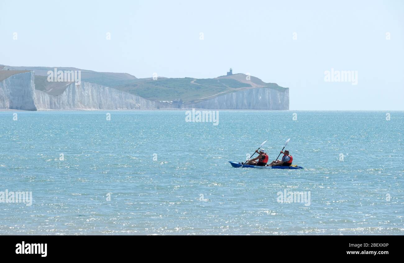 Two men kayak paddle towards the shore. Birling Gap, the Seven Sisters