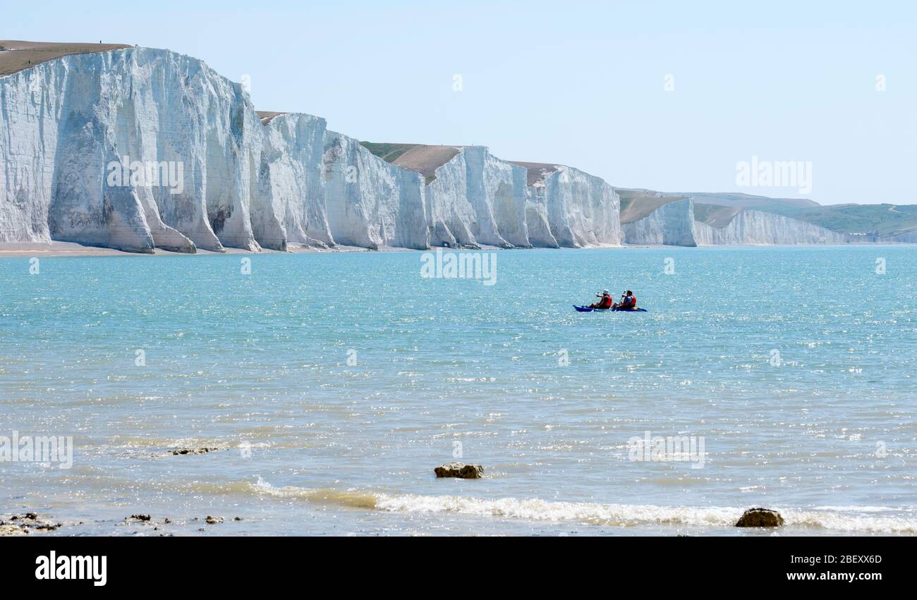 Two men kayak paddle towards the shore. Seven Sisters and Cuckmere Haven from Seaford Head, East Sussex, England, UK Stock Photo