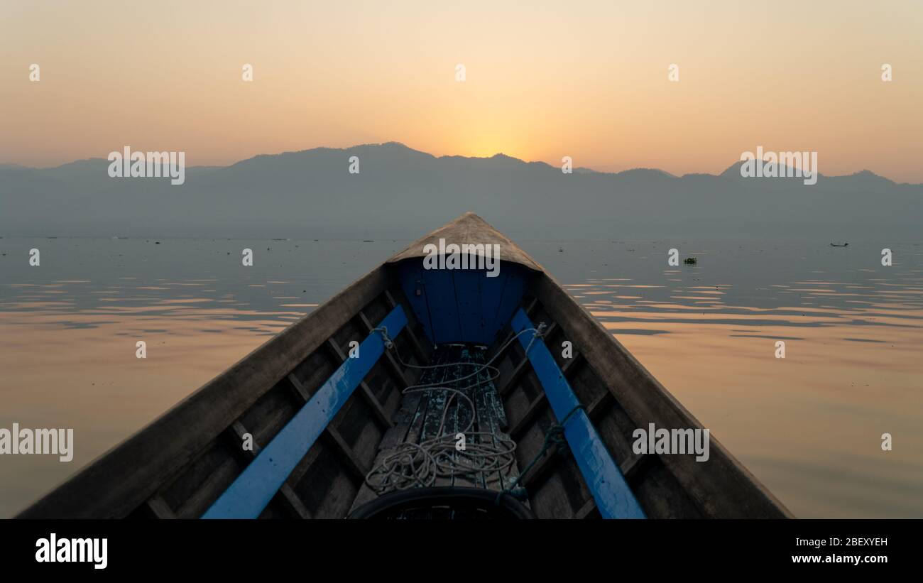 Boat tour point of view Inle Lake, Myanmar. Sunrise early morning mountain silhouette tranquil freshwater fishing lake. Over twenty species of snails Stock Photo