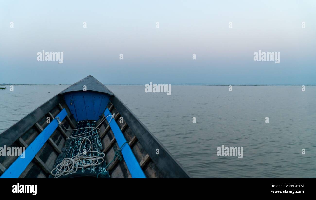 Boat point of view Inle Lake, Myanmar. Room for copy sunrise still lake, morning mist still lake. Over twenty species of snails and nine species of fi Stock Photo