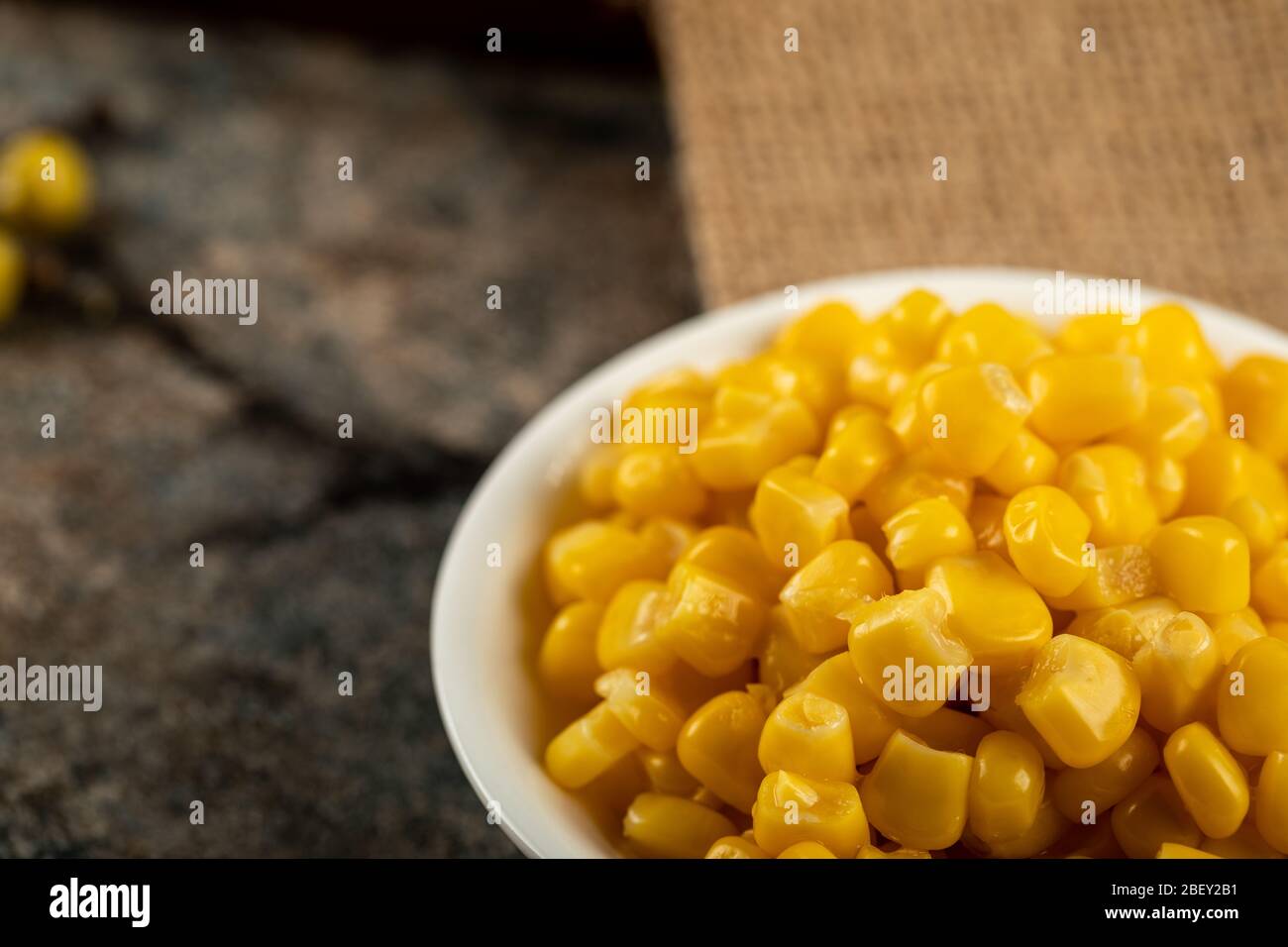 Marinated corn seeds in a white saucer Stock Photo