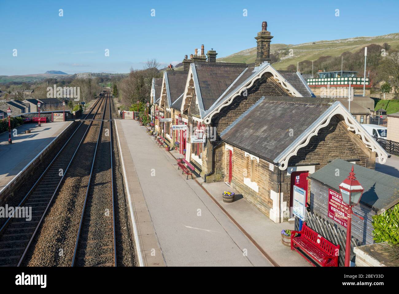 The traditionally styled footbridge and train station at Settle on the famous Settle to Carlisle railway line Stock Photo