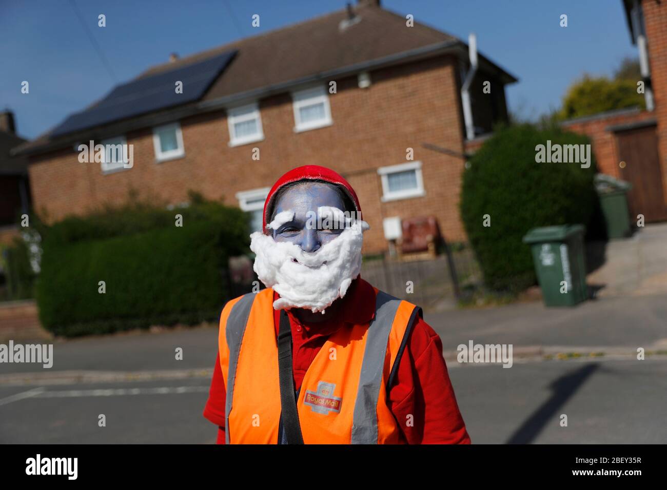 Loughborough, Leicestershire, UK. 16th April 2020. A Royal Mail Postwoman wears Smurf fancy dress in support of the NHS as she delivers post during the coronavirus pandemic lockdown. Credit Darren Staples/Alamy Live News. Stock Photo