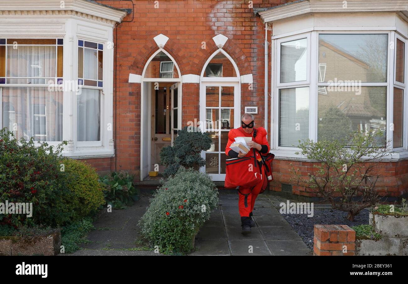 Loughborough, Leicestershire, UK. 16th April 2020. Royal Mail Postman Kevin Allen wears Mr Incredible fancy dress in support of the NHS as he delivers post during the coronavirus pandemic lockdown. Credit Darren Staples/Alamy Live News. Stock Photo
