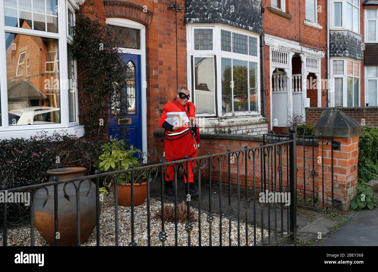 Loughborough, Leicestershire, UK. 16th April 2020. Royal Mail Postman Kevin Allen wears Mr Incredible fancy dress in support of the NHS as he delivers post during the coronavirus pandemic lockdown. Credit Darren Staples/Alamy Live News. Stock Photo
