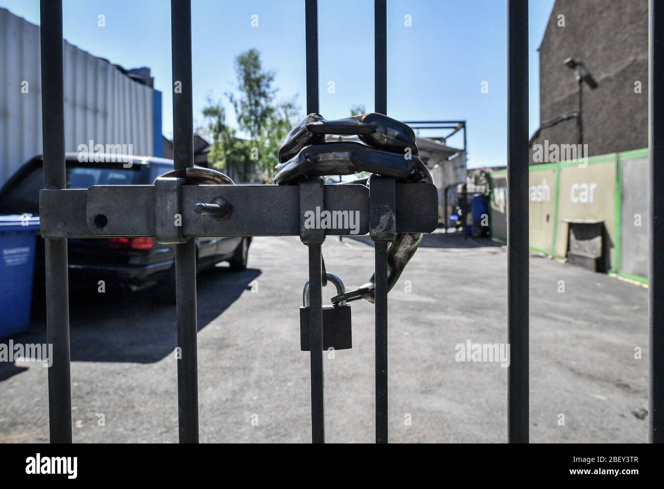 NOTE: IMAGE 33 OF A SET OF 35 IMAGES FEATURING LOCKED GATES OF BUSINESSES AND PLACES THAT ARE CLOSED DURING UK LOCKDOWN A brass padlock is used to prevent access to a car wash site in Bristol as the UK continues in lockdown to help curb the spread of the coronavirus. Stock Photo