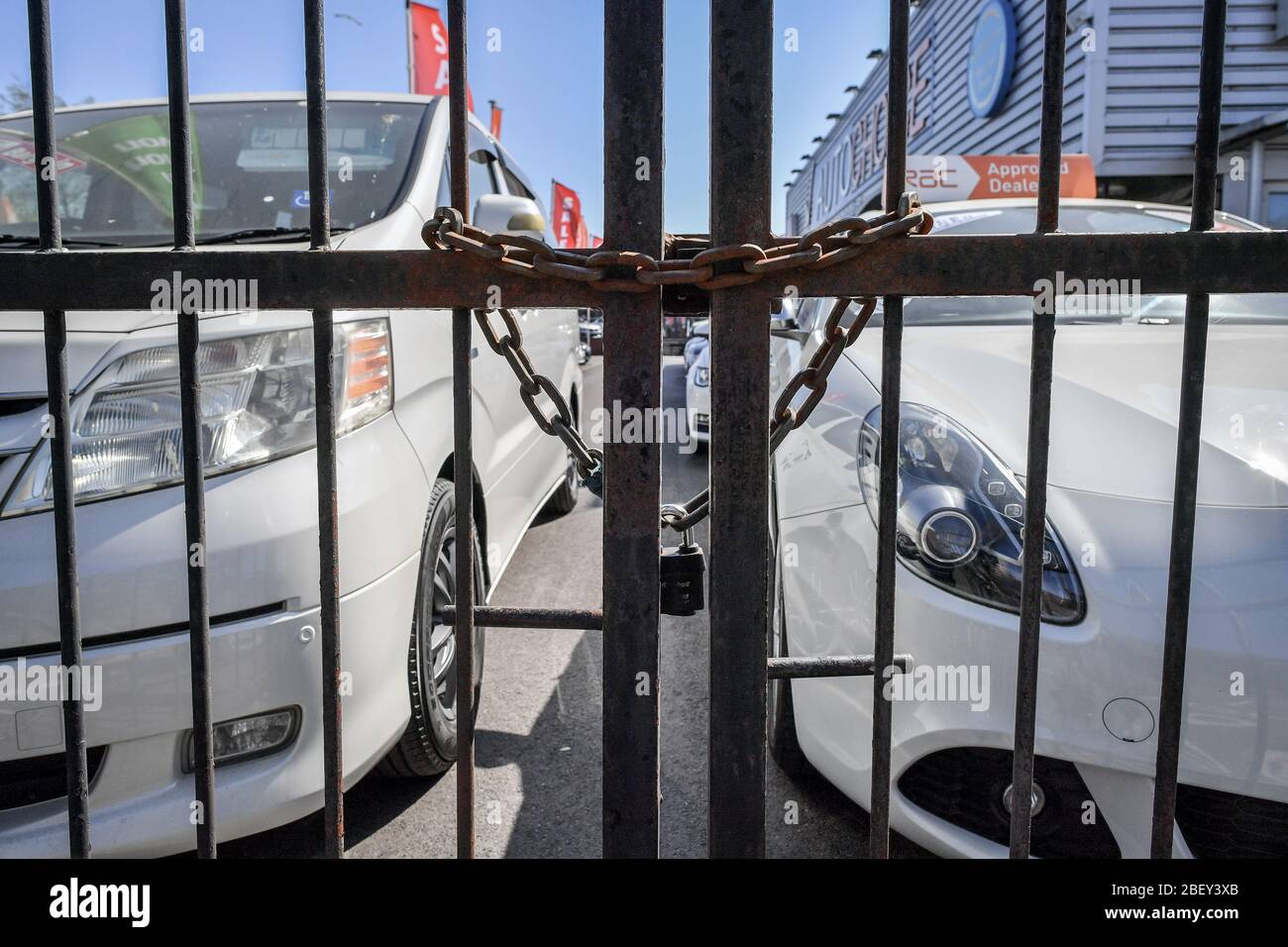 NOTE: IMAGE 30 OF A SET OF 35 IMAGES FEATURING LOCKED GATES OF BUSINESSES AND PLACES THAT ARE CLOSED DURING UK LOCKDOWN A chain is looped through steel gates at a car sales forecourt in Bristol to prevent access as the UK continues in lockdown to help curb the spread of the coronavirus. Stock Photo