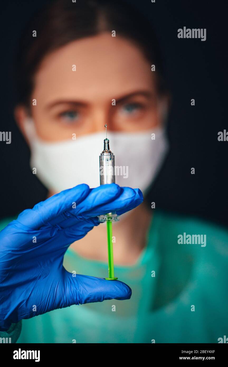 Coronavirus Covid-19 Protection and Vaccine. Female medical Scientist working on Vaccine from from, flu, coronavirus, ebola, TB. Protective suit and m Stock Photo