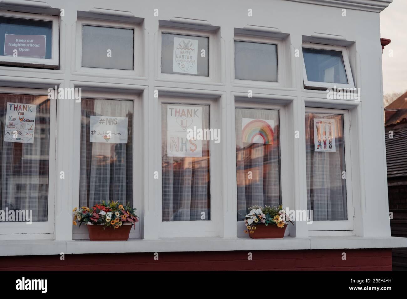 London, UK - April 12, 2020: Signs with rainbow, stay safe and thank you NHS messages in a window of a house as people express gratitude towards NHS s Stock Photo
