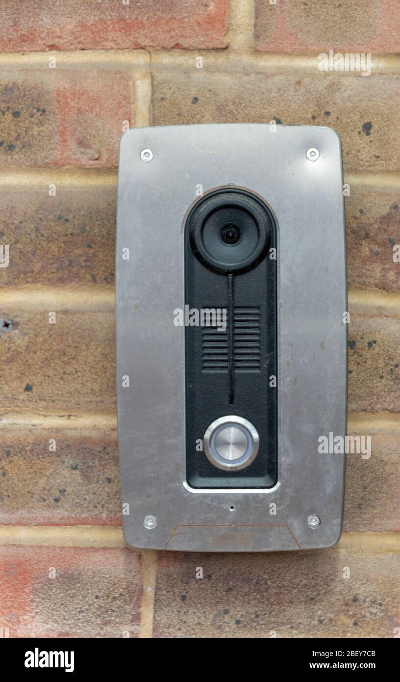 a close up view of a camera intercom mounted on a brick face wall Stock Photo