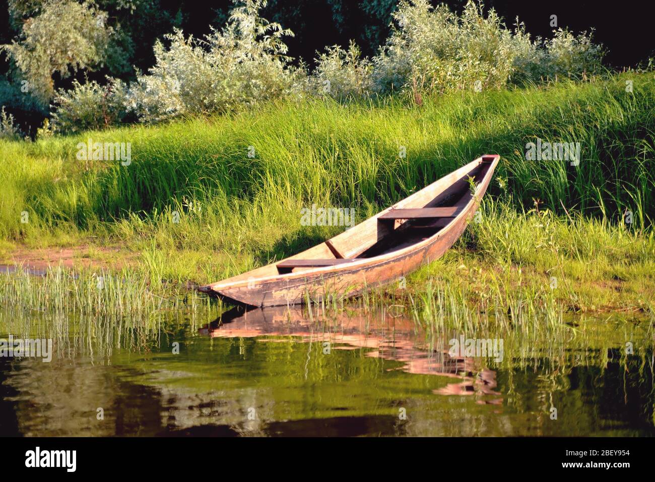 old wooden boat on the river bank close up against the background of ...