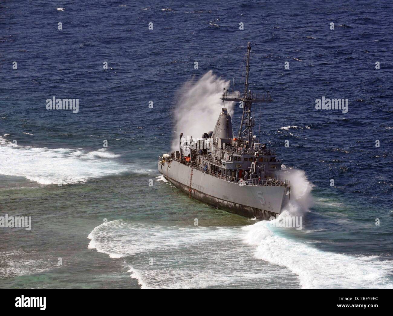 SULU SEA (Jan. 29, 2013) Heavy waves crash against the grounded mine countermeasure ship USS Guardian (MCM 5), which ran aground on the Tubbataha Reef in the Sulu Sea on Jan. 17. The grounding and subsequent heavy waves constantly hitting Guardian have caused severe damage, leading the Navy to determine the 23-year old ship is beyond economical repair and is a complete loss. With the deteriorating integrity of the ship, the weight involved, and where it has grounded on the reef, dismantling the ship in sections is the only supportable salvage option. The U.S. Navy continues to work in close co Stock Photo