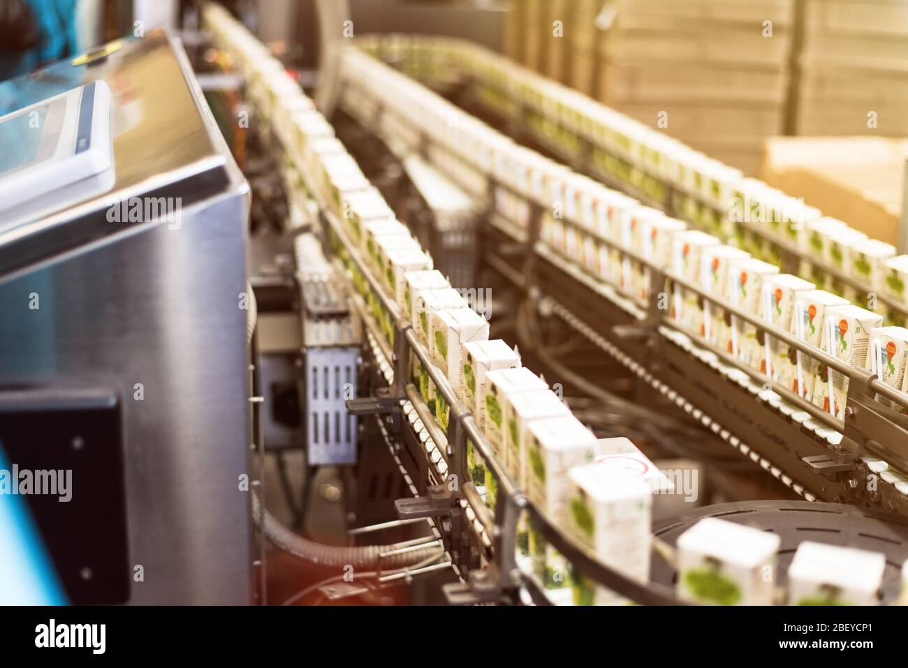Conveyor with box for juice or water. Conveyor at the plant for the production and bottling of juices in cardboard packaging Stock Photo