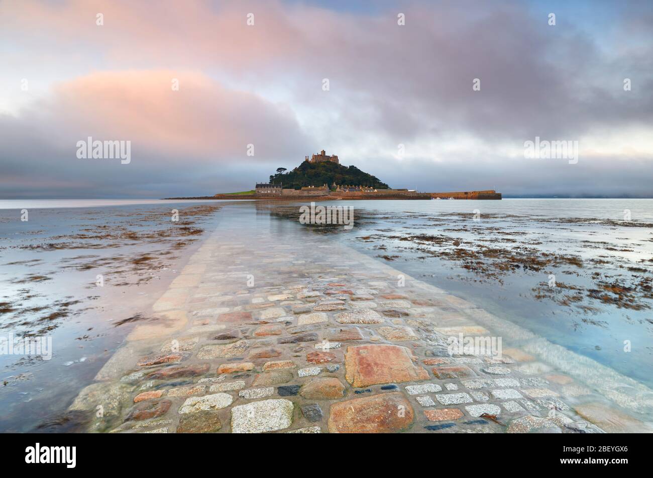 Low lying cloud lit by the rising sun above St Michael's Mount and the cornish mainland. Stock Photo