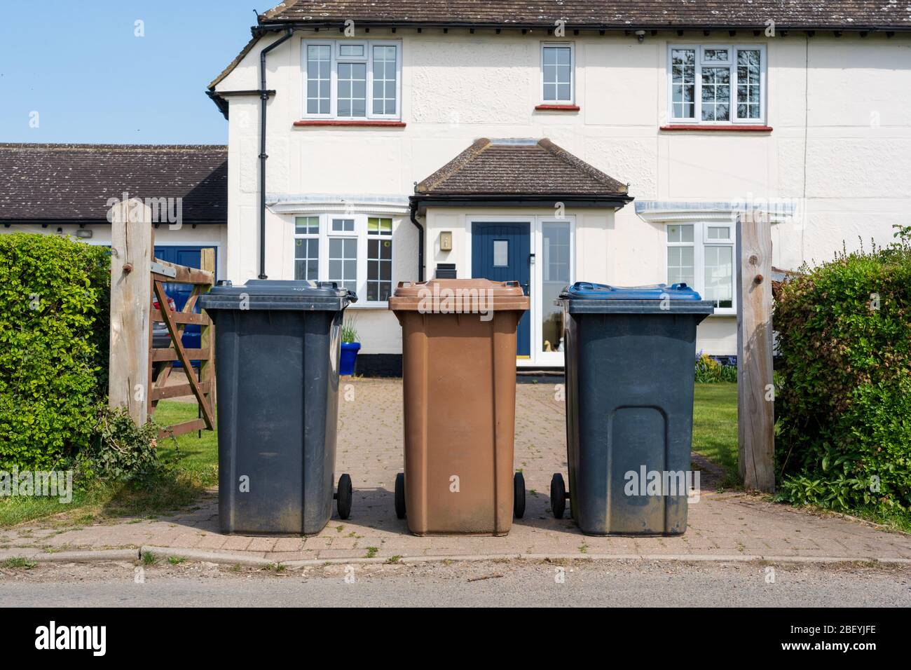Row of three wheelie bins outside house ready to be emptied by refuse