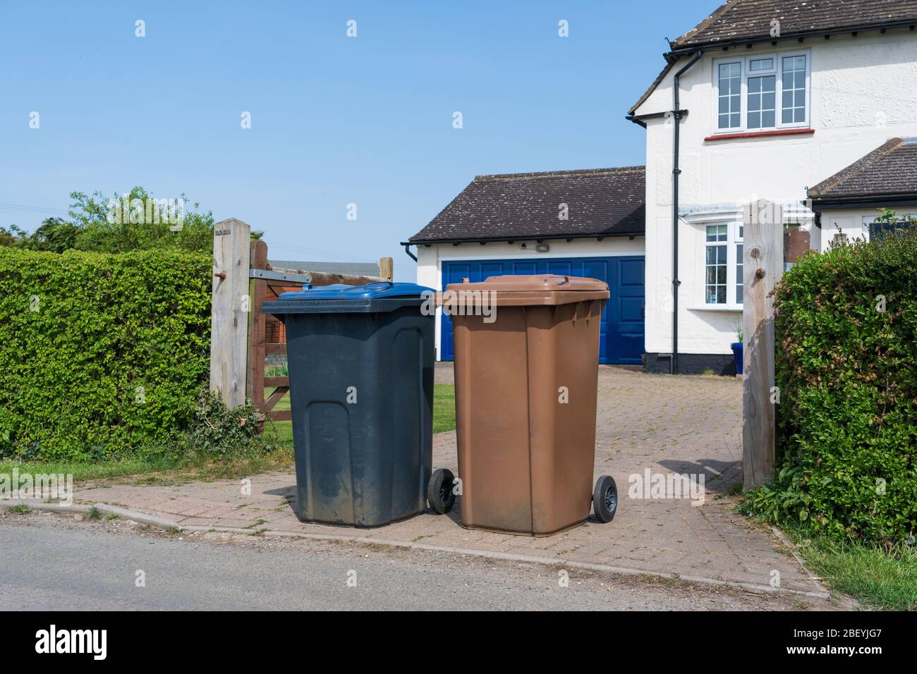 Two wheelie bins outside house ready to be emptied by refuse collectors. Much Hadham, Hertfordshire. UK Stock Photo