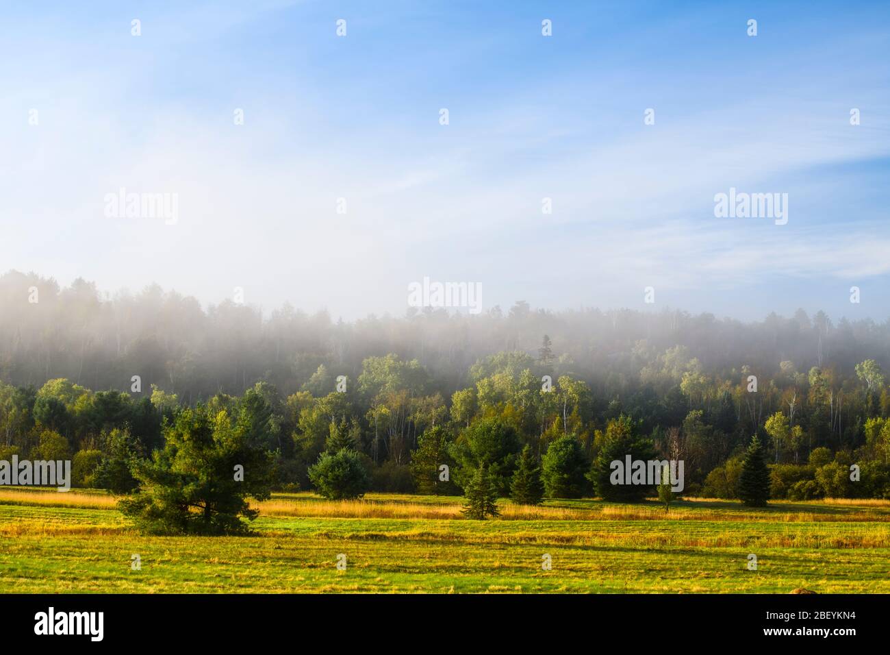 Morning mists and a hillside near a hayfield, Greater Sudbury, Ontario, Canada Stock Photo