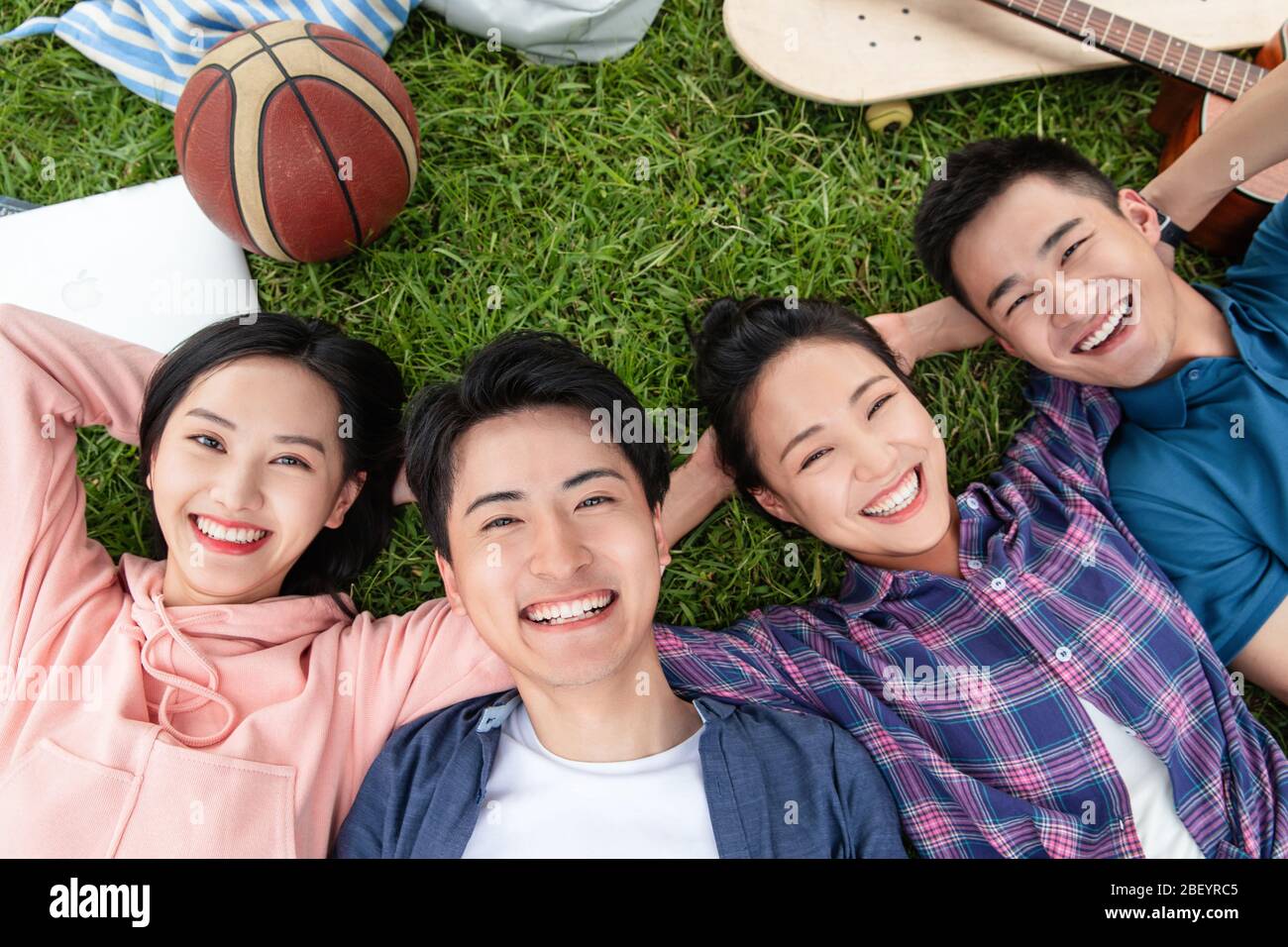 Happy students lay on the grass Stock Photo