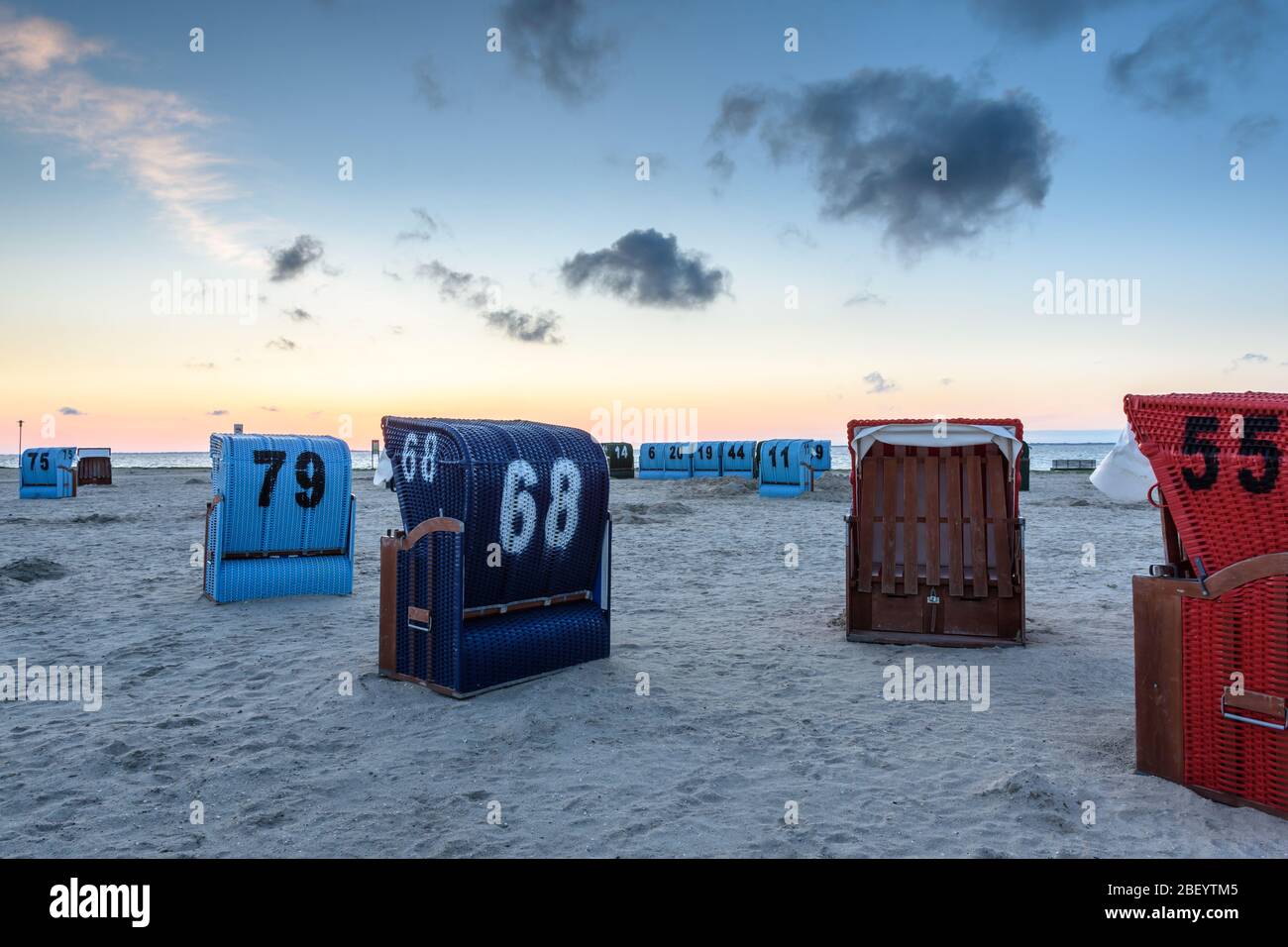 Wicker beach chairs at the beach in Neuharlingersiel at dusk, East Frisia, Lower Saxony, Germany Stock Photo