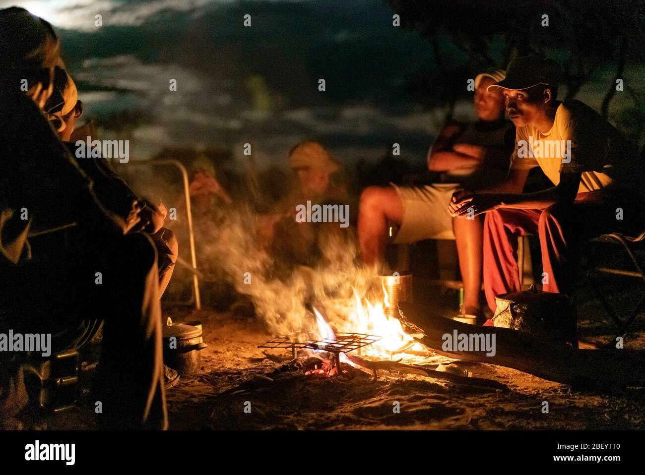 Jo/hoansi men gather around the fire and tell stories in Nyae Nyae, Namibia. Stock Photo