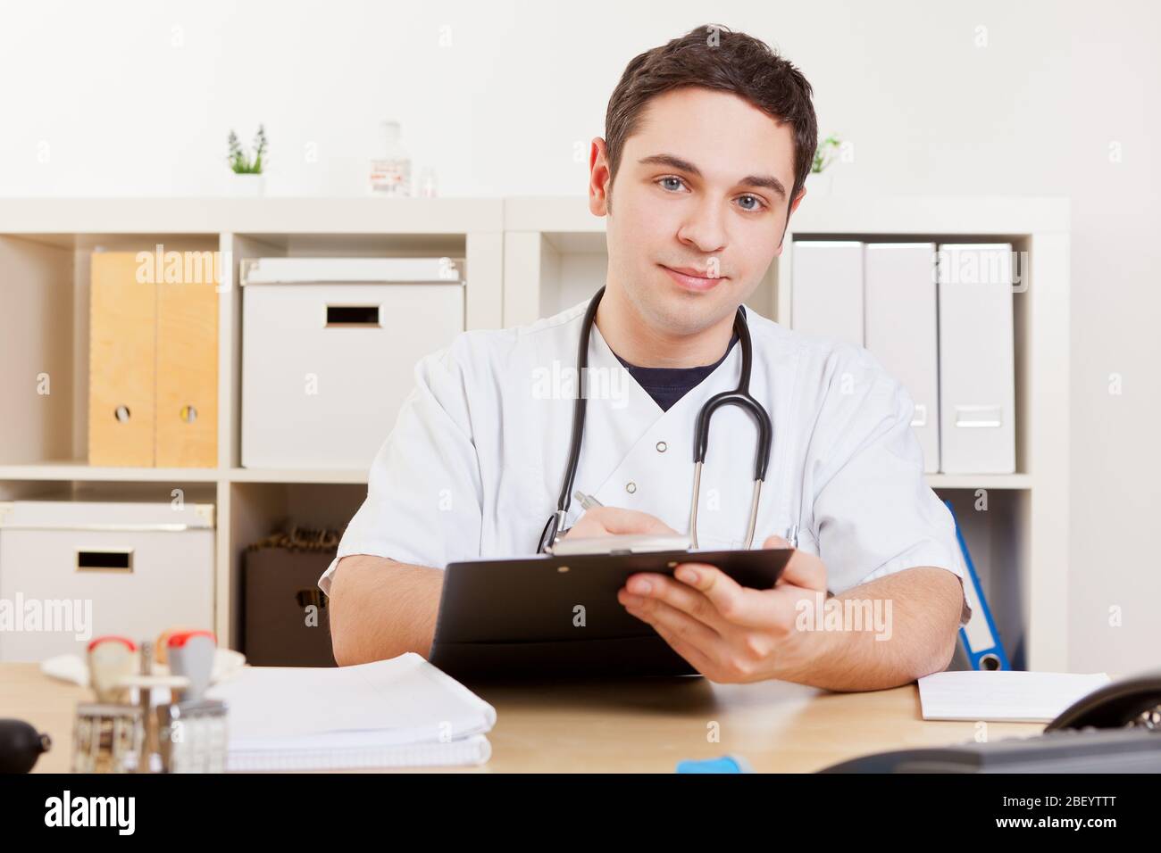 Doctor in his practice takes notes on the clipboard Stock Photo