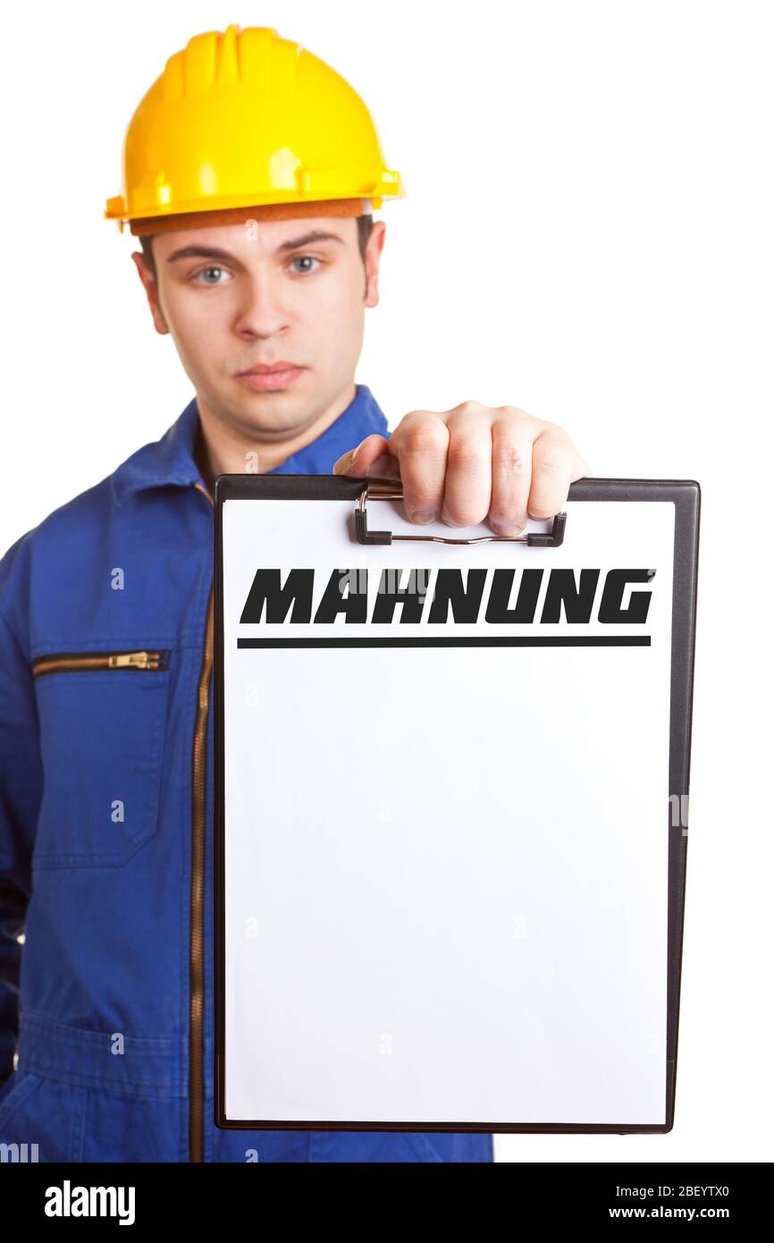 Craftsman in overalls with hard hat holds a 'Mahnung' (German for reminder) on clipboard Stock Photo
