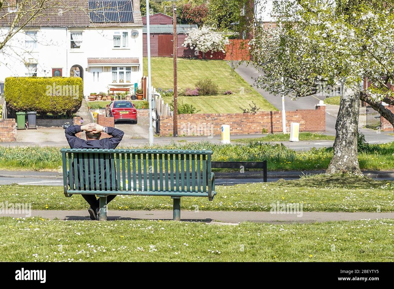 Kidderminster, UK. 16th April, 2020. Under the UK's current lockdown rules, people should be staying at home, coming out only to exercise once a day - be it cycling, jogging, or walking. This man is clearly flouting the coronavirus lockdown rules as he spends time relaxing on a park bench enjoying the April sunshine without any good reason for doing so. This is one individual with complete disregard for the critical 'Stay Home, Protect the NHS, Save Lives' government advice. Credit: Lee Hudson/Alamy Live News Stock Photo