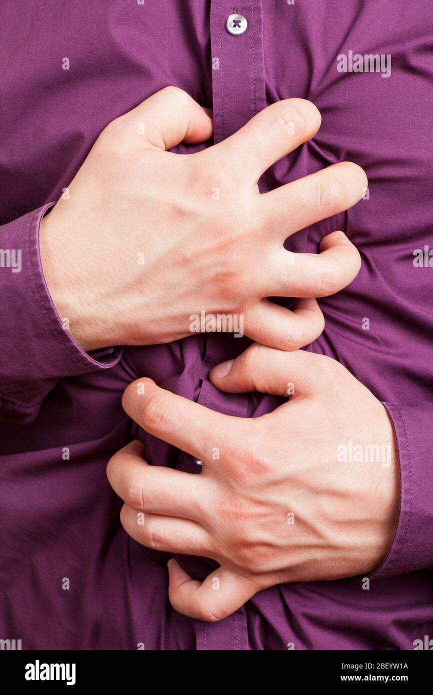 Cramping hands hold the aching belly for abdominal pain Stock Photo