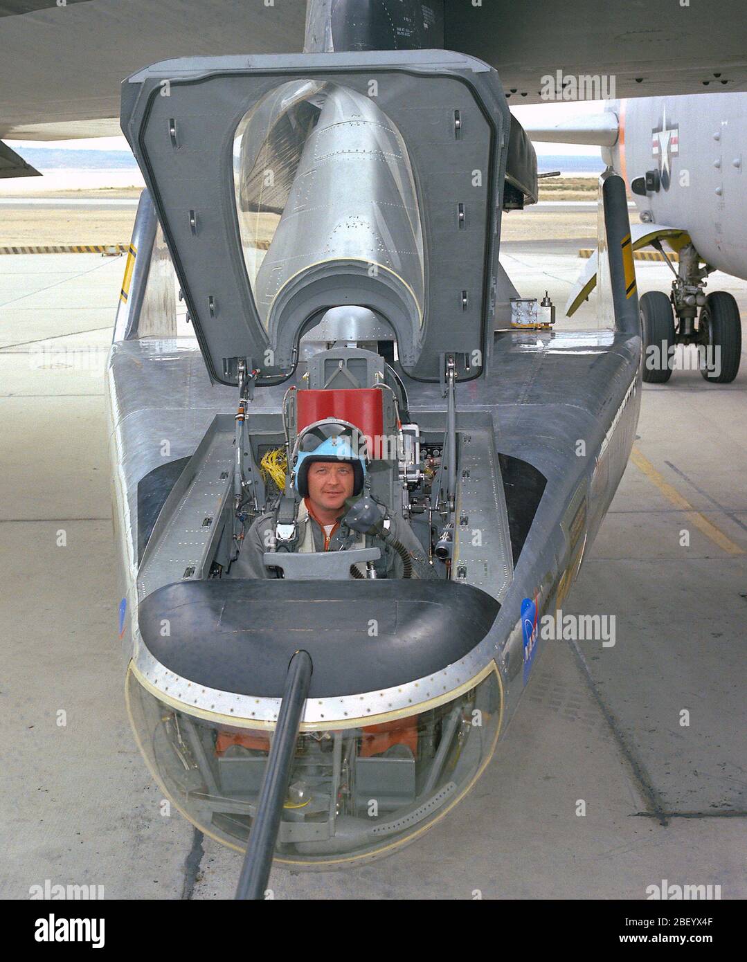 NASA research pilot Milt Thompson sits in the M2-F2 'heavyweight' lifting body research vehicle before a 1966 test flight. The M2-F2 and the other lifting-body designs were all attached to a wing pylon on NASA’s B-52 mothership and carried aloft. The vehicles were then drop-launched and, at the end of their flights, glided back to wheeled landings on the dry lake or runway at Edwards AFB. The lifting body designs influenced the design of the Space Shuttle and were also reincarnated in the design of the X-38 in the 1990s. Stock Photo