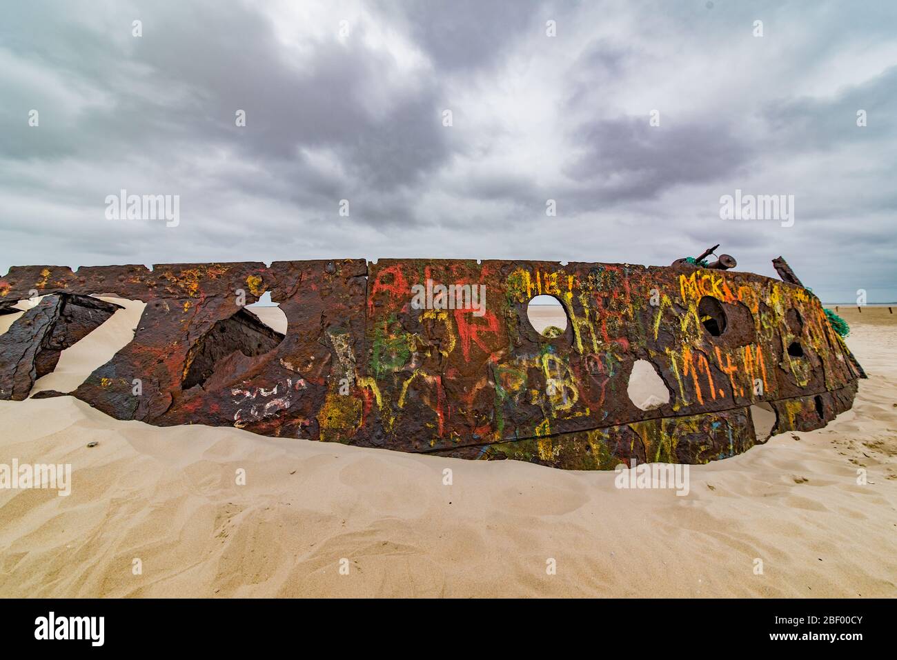 Rusty shipwreck with grafiti on island of Norderney, germany Stock Photo