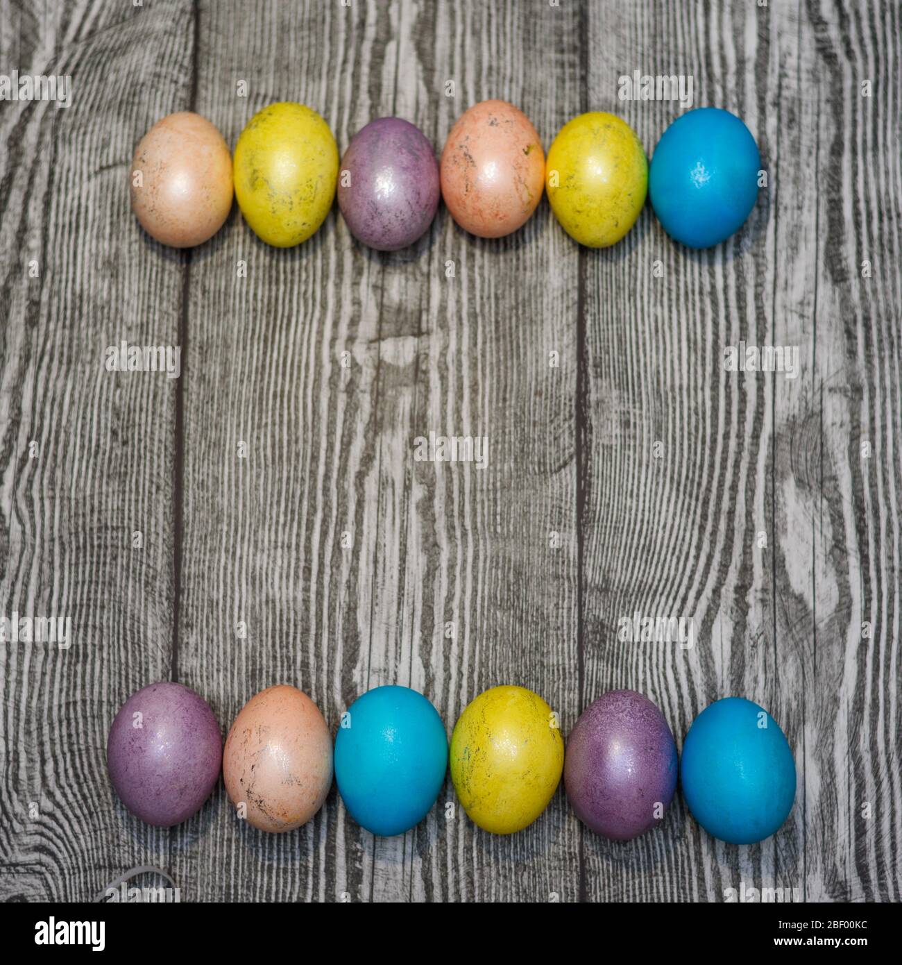 Many multi colored easter eggs on the wooden background. Space for text. Stock Photo