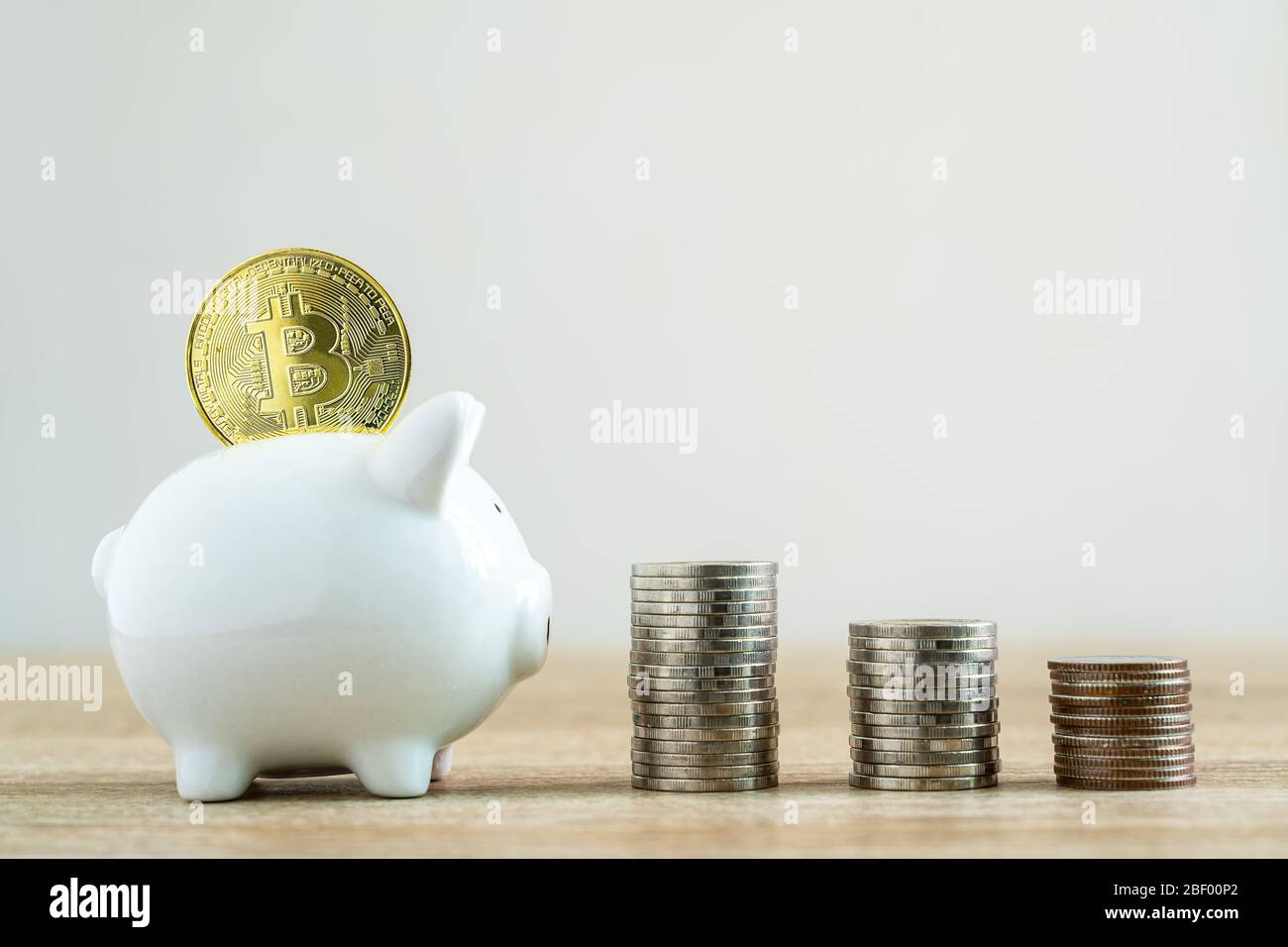 Money savings concepts stack coin with bitcoin to put in piggy bank to spend on expenses such as savings, tourism, investment, emergency, retirement o Stock Photo