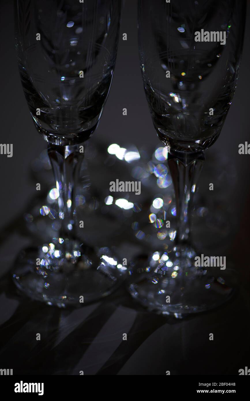 Champagne glasses made of crystal illuminated in a dark room. Concept : artistic minimalism. Stock Photo