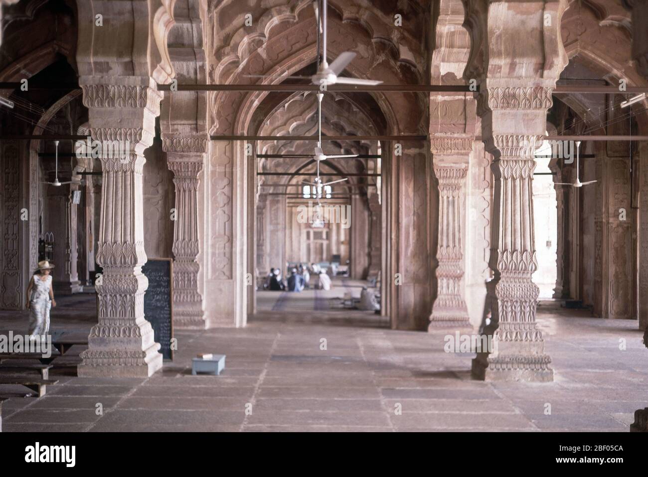 INTERIOR-ARCADAS DE LA MEZQUITA CON GENTE REZANDO AL FONDO. Author: QUDSIA BEGUM. Location: MEZQUITA JAMI MASJID. Bhopal. India. Stock Photo