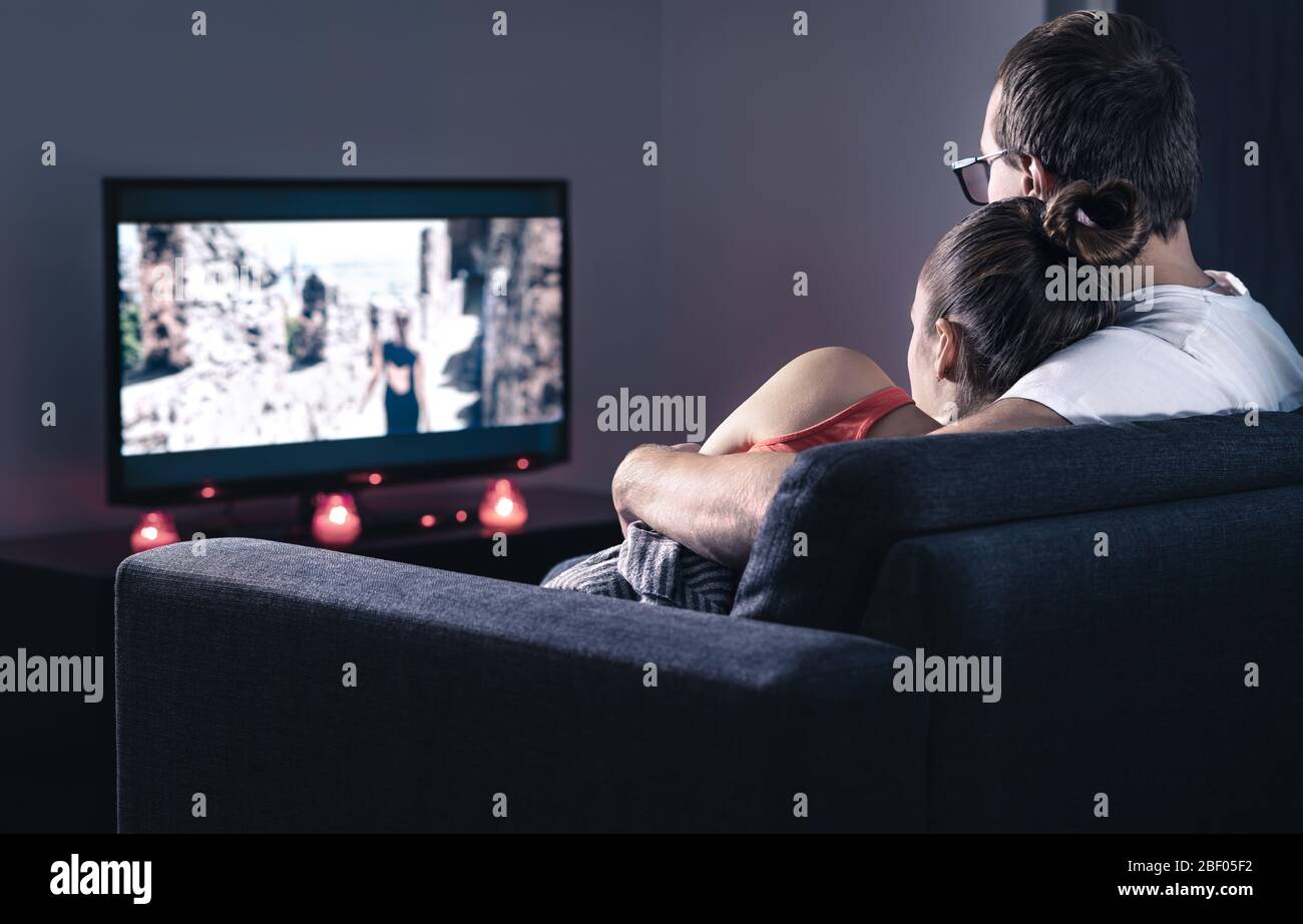 Couple watching movie or series. Online streaming and VOD service in tv screen. Film stream or television show. Stock Photo