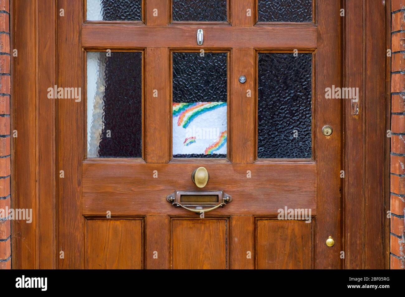 Chippenham, Wiltshire UK, 16th April, 2020. With the nation due to once again clap to show their support for the NHS tonight, a childs drawing of a rainbow (a symbol of support for people wanting to show solidarity with NHS workers) is pictured on a front door of a home in Chippenham, Wiltshire. Credit: Lynchpics/Alamy Live News Stock Photo