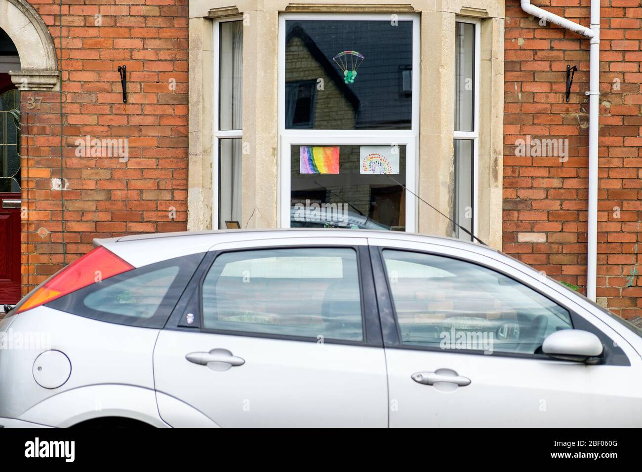 Chippenham, Wiltshire UK, 16th April, 2020. With the nation due to once again clap to show their support for the NHS tonight, a childs drawing of a rainbow (a symbol of support for people wanting to show solidarity with NHS workers) is pictured in a front window of a home in Chippenham, Wiltshire. Credit: Lynchpics/Alamy Live News Stock Photo