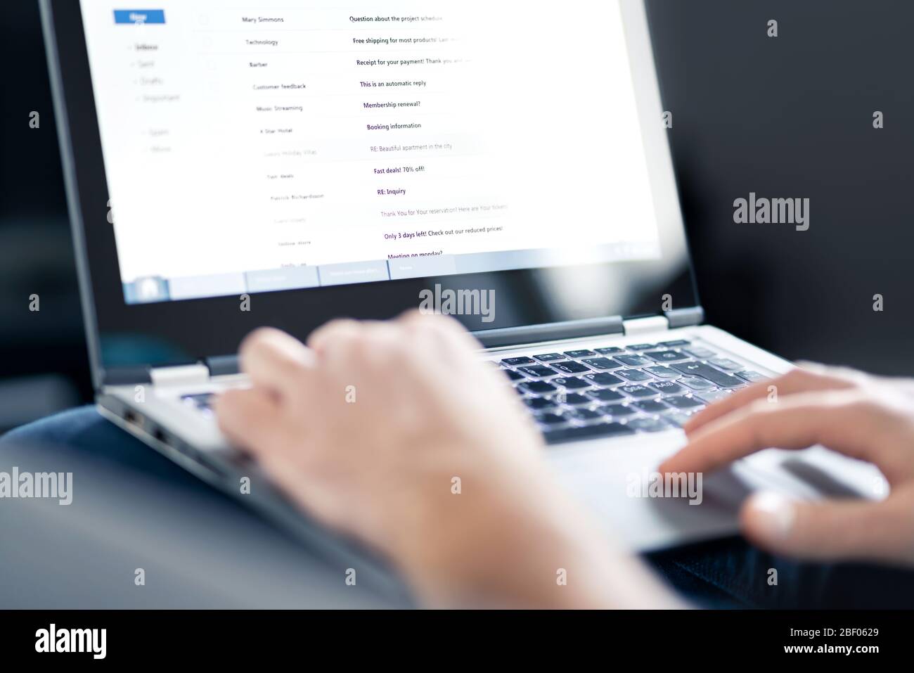 Email inbox full of messages and text. Man reading electronic mail with laptop. Spam, junk and e marketing on screen. Stock Photo