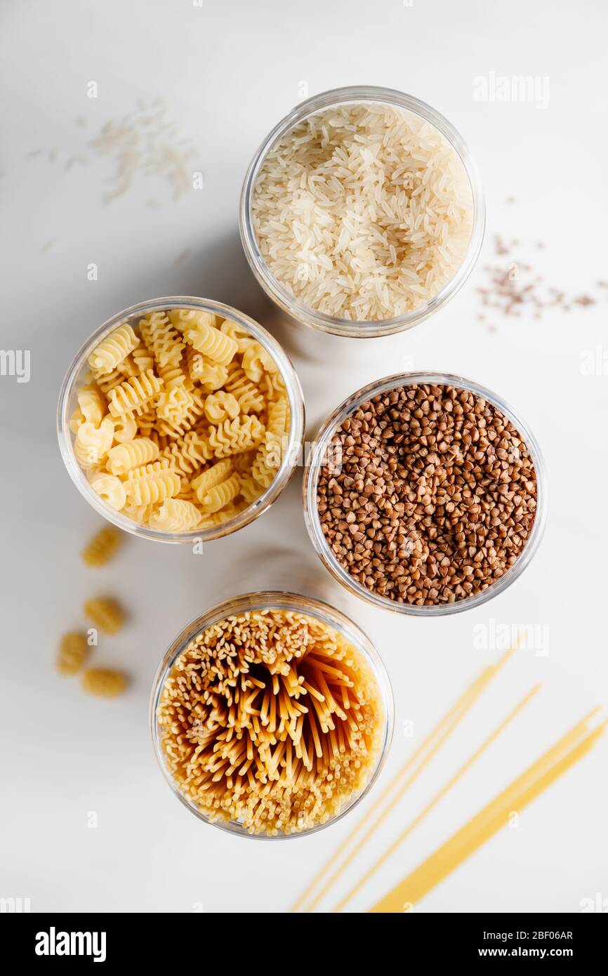 Various pasta and cereal grains in a plastic jars for a long storage. Stock Photo