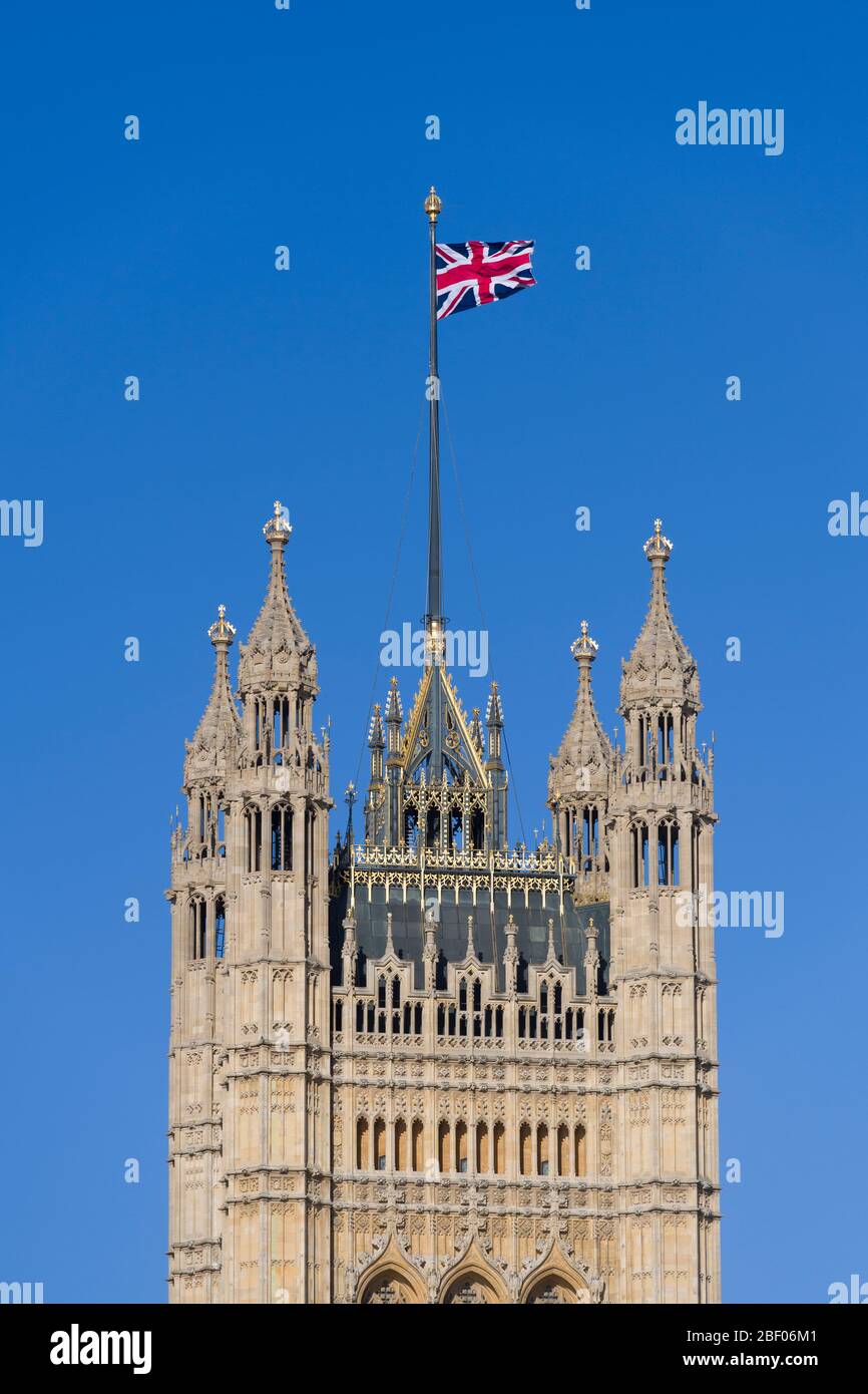 A Union Jack flag flying from, The Victoria Tower, Palace of Westminster commonly known as the Houses of Parliament, which is the meeting place of the Stock Photo