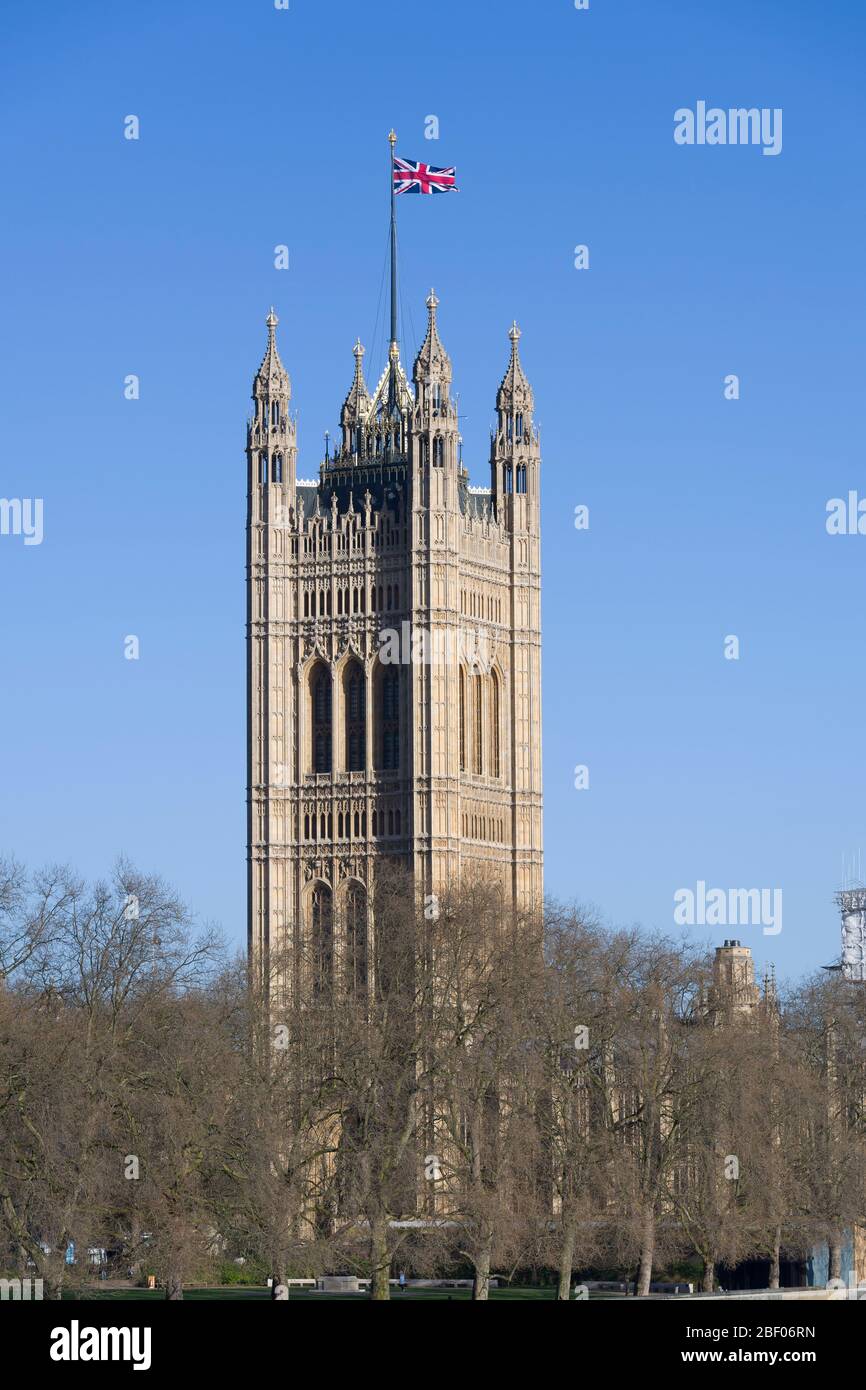 A Union Jack flag flying from, The Victoria Tower, Palace of Westminster commonly known as the Houses of Parliament, which is the meeting place of the Stock Photo