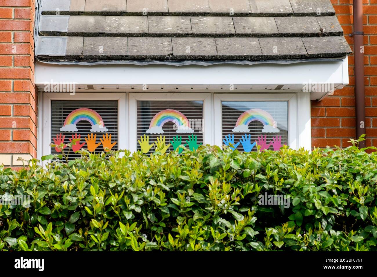 Chippenham, Wiltshire UK, 16th April, 2020. With the nation due to once again clap to show their support for the NHS tonight, a childs rainbow drawings (a symbol of support for people wanting to show solidarity with NHS workers) are pictured in a front window of a home in Chippenham, Wiltshire. Credit: Lynchpics/Alamy Live News Stock Photo