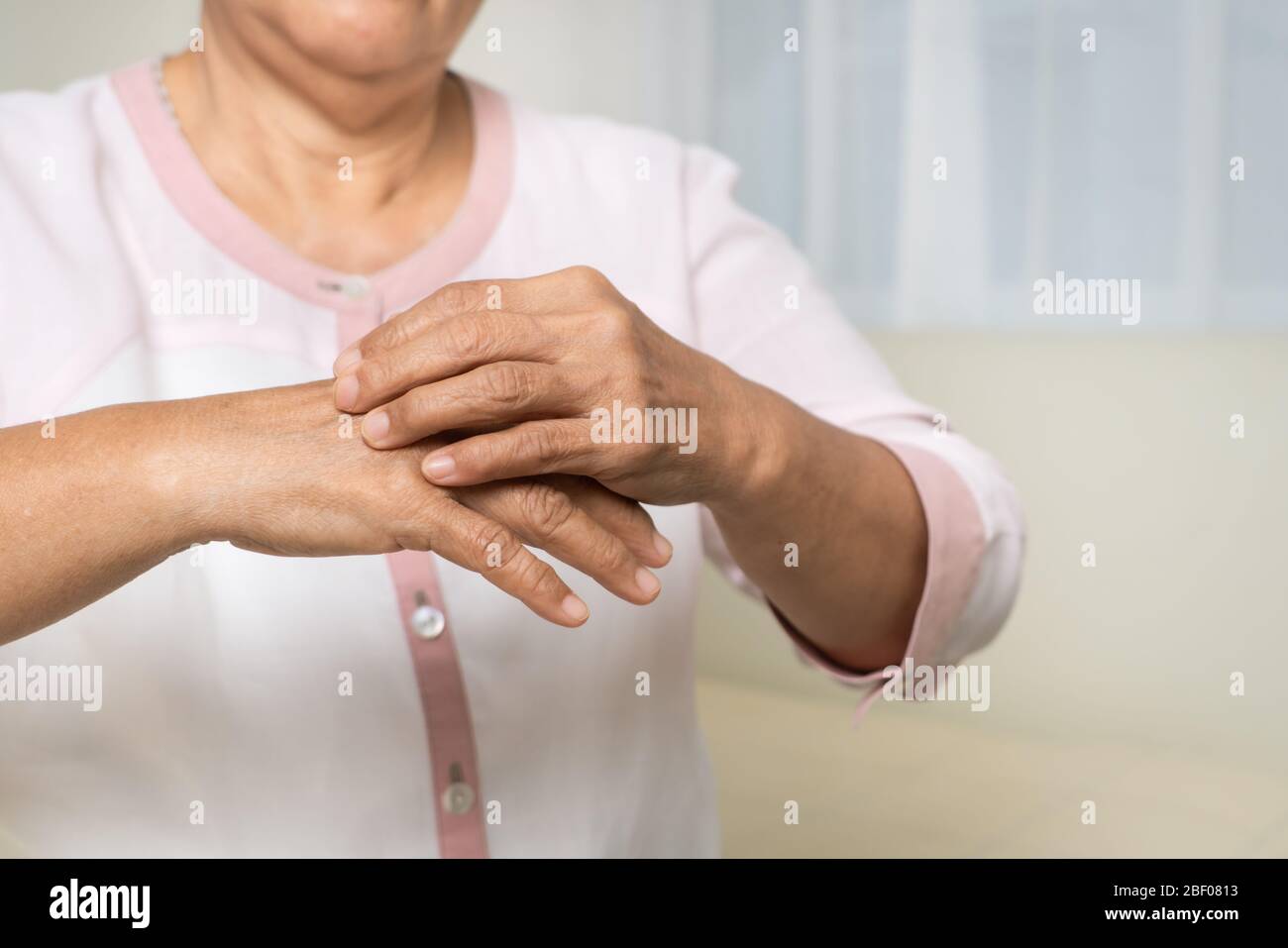 senior women scratch hand the itch on eczema arm, healthcare and medicine concept Stock Photo